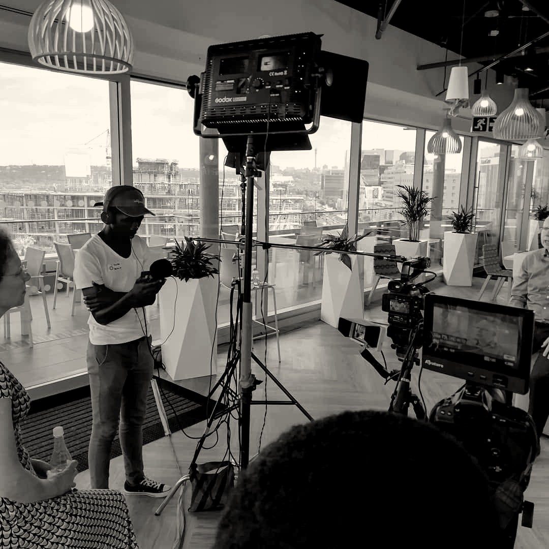Lights, camera and monitor set up for an interview in a glass-walled office