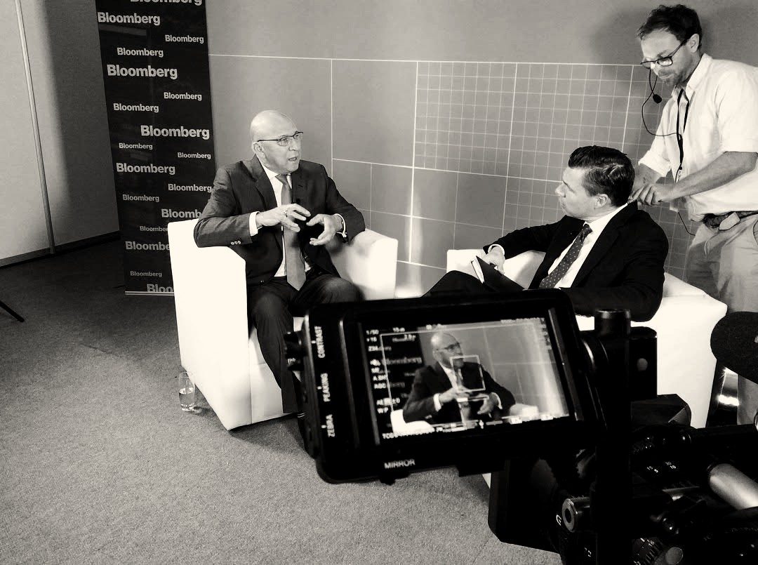 Camera viewfinder framing a seated interview guest on a Bloomberg set