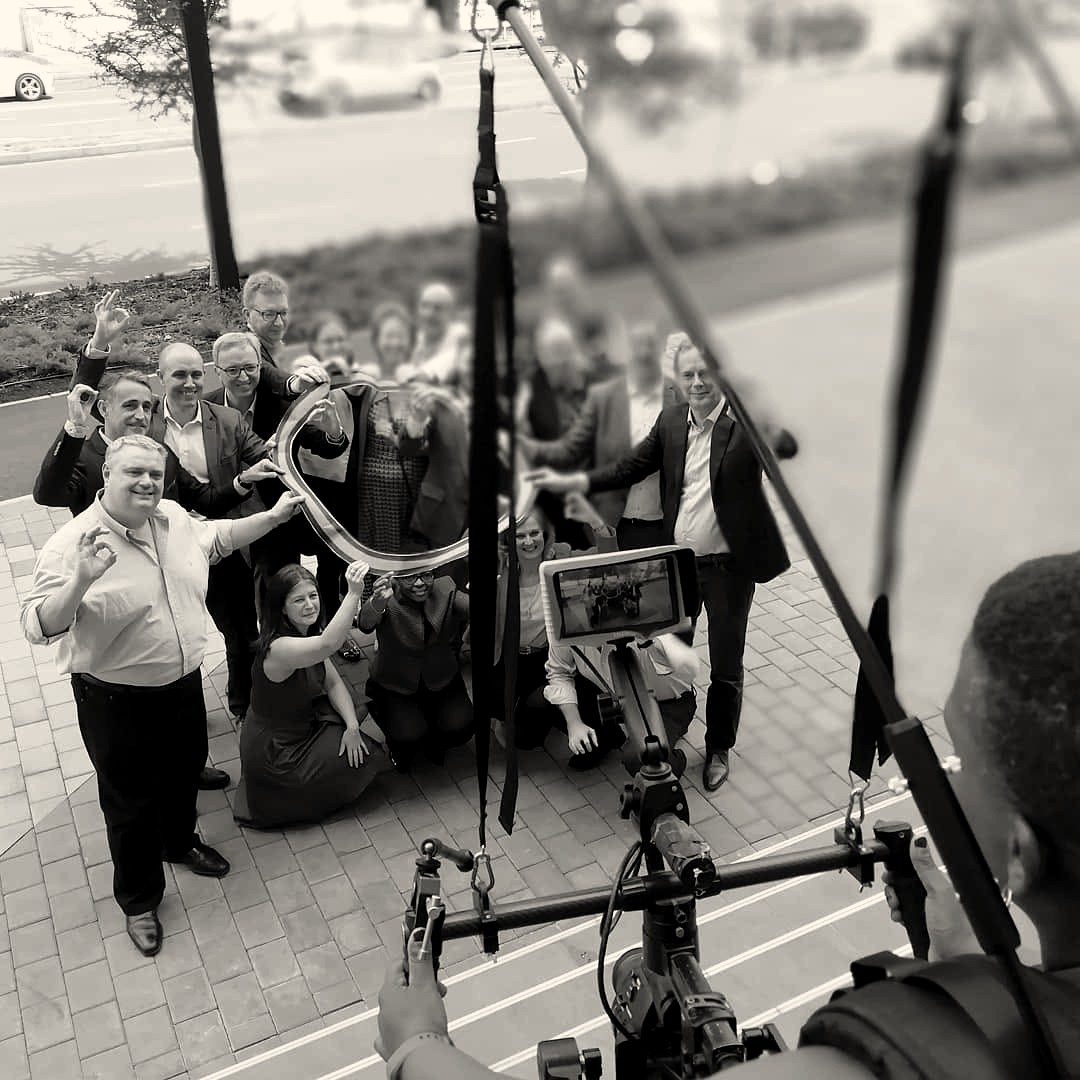 A gimbal camera filming a smiling group of people from above