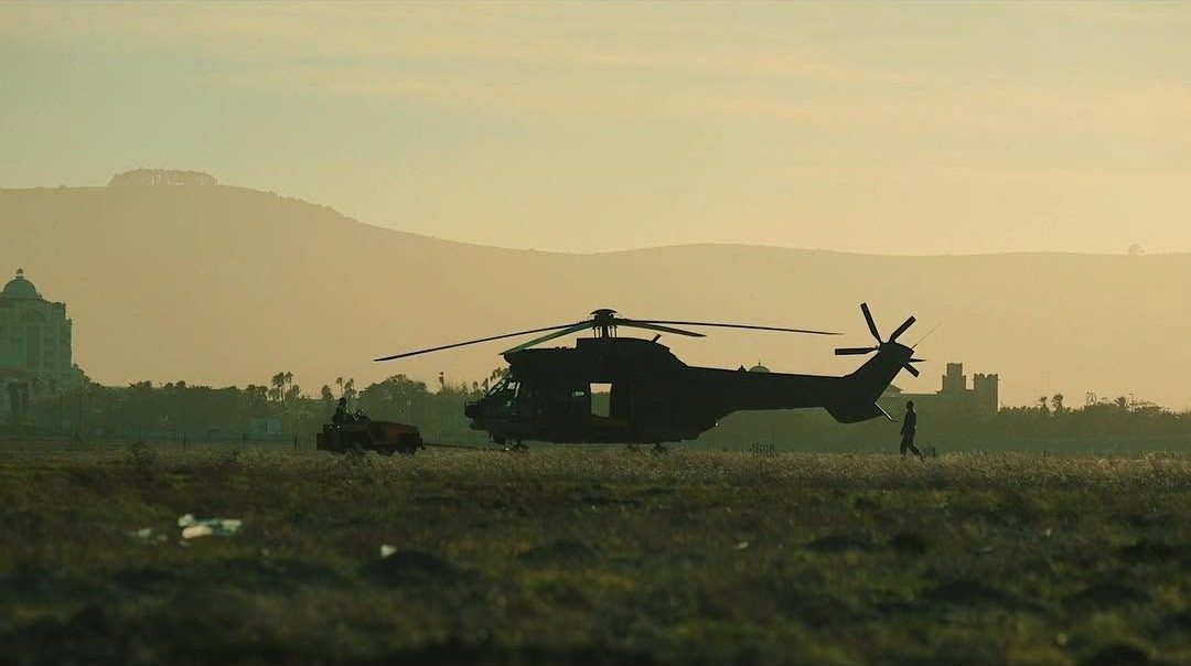 Film still: a helicopter on an airfield at golden hour
